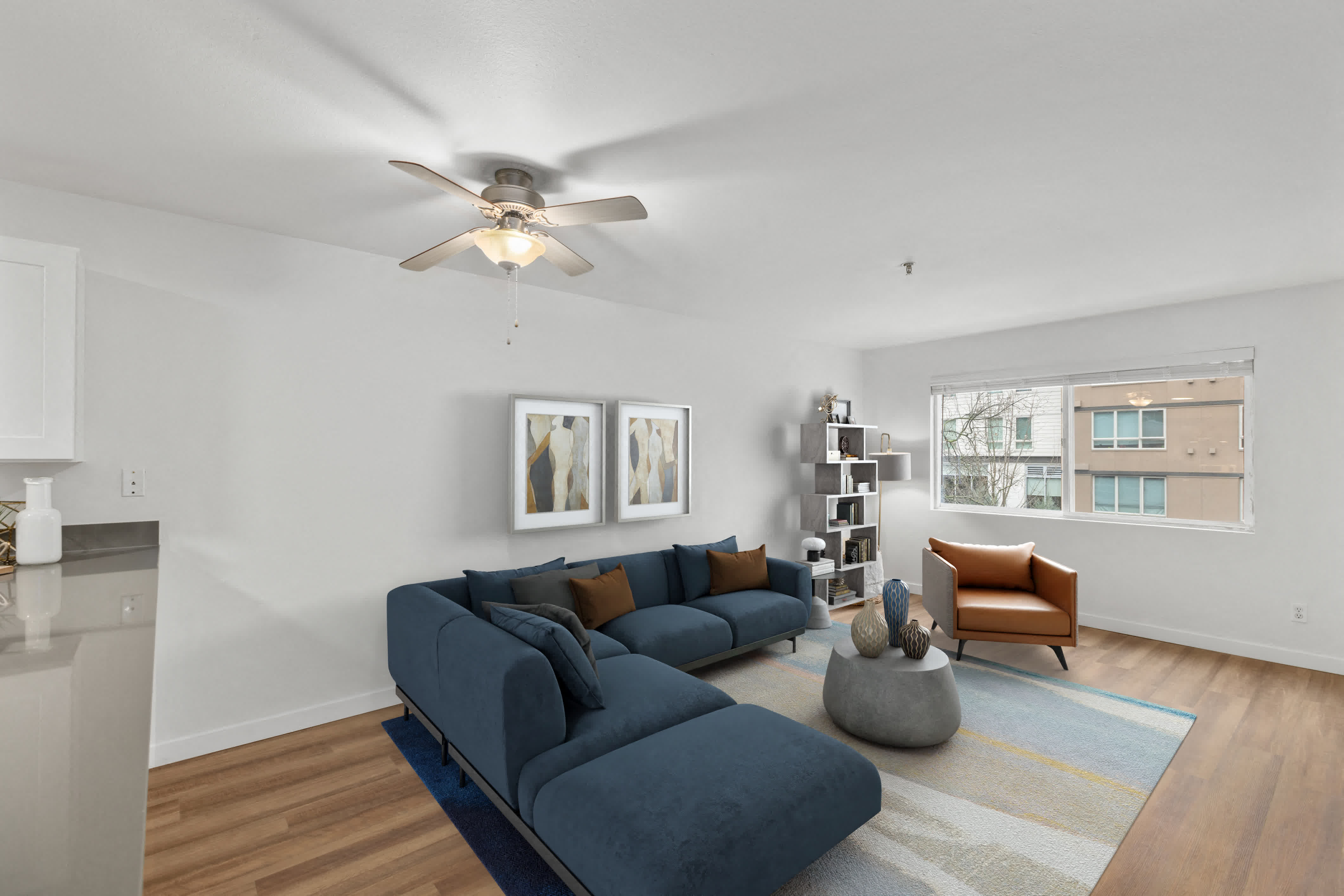 a living room with a blue couch and a ceiling fan