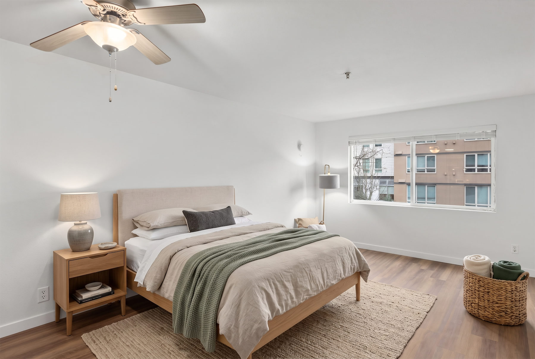 A bedroom with a bed, nightstand, and window.