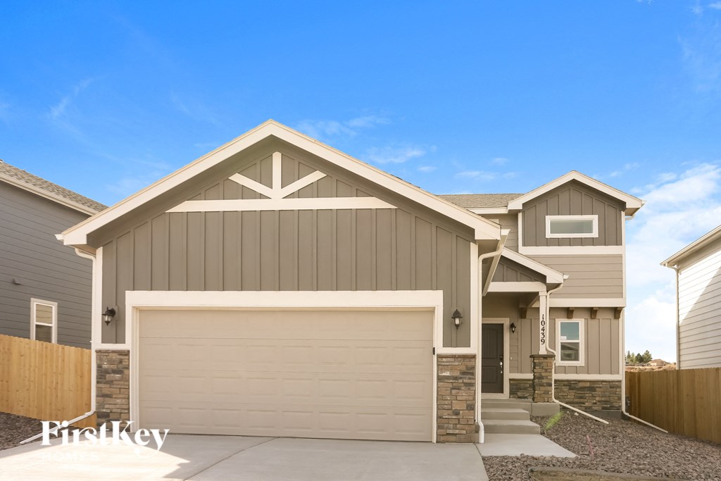 a tan and brown house with a garage door