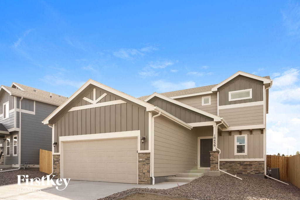 a tan and brown house with a garage door