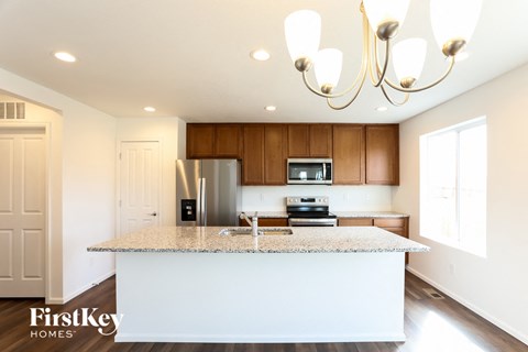 a white kitchen with a granite counter top and