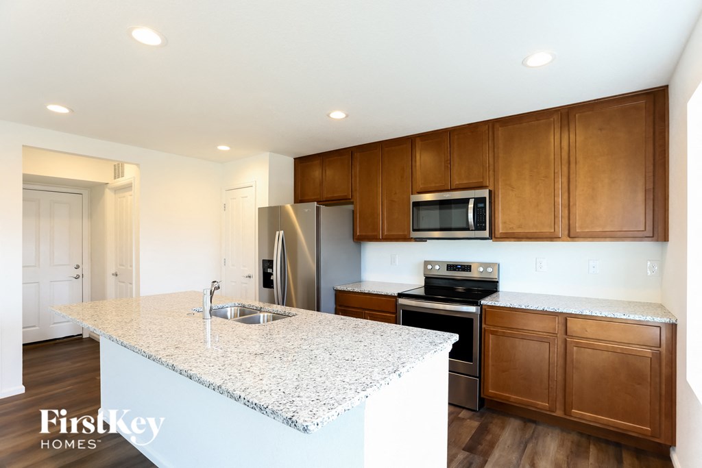 a kitchen with granite counter tops and wooden cabinets