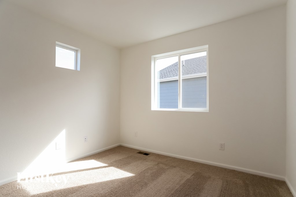 an empty room with two windows in it