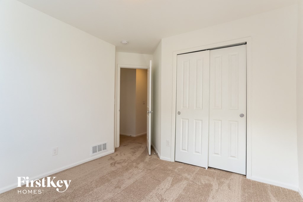 a bedroom with a closet and a door to a hallway