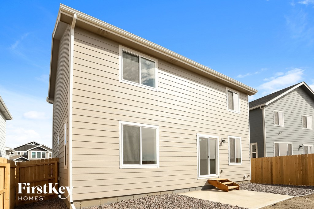 a new house with a wooden fence and a blue sky