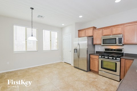 A kitchen with a stainless steel refrigerator, microwave, and oven.