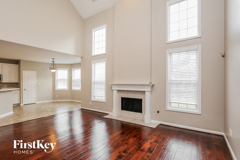an empty living room with a fireplace and wooden floors