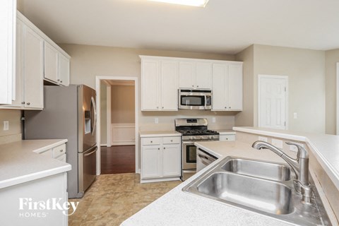 a kitchen with white cabinets and a stainless steel sink