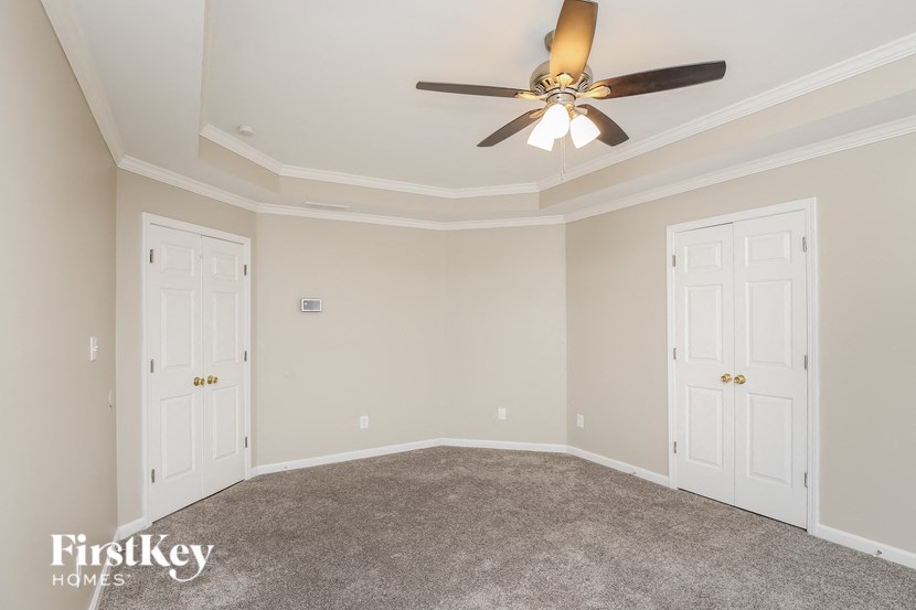 a bedroom with a ceiling fan and two doors