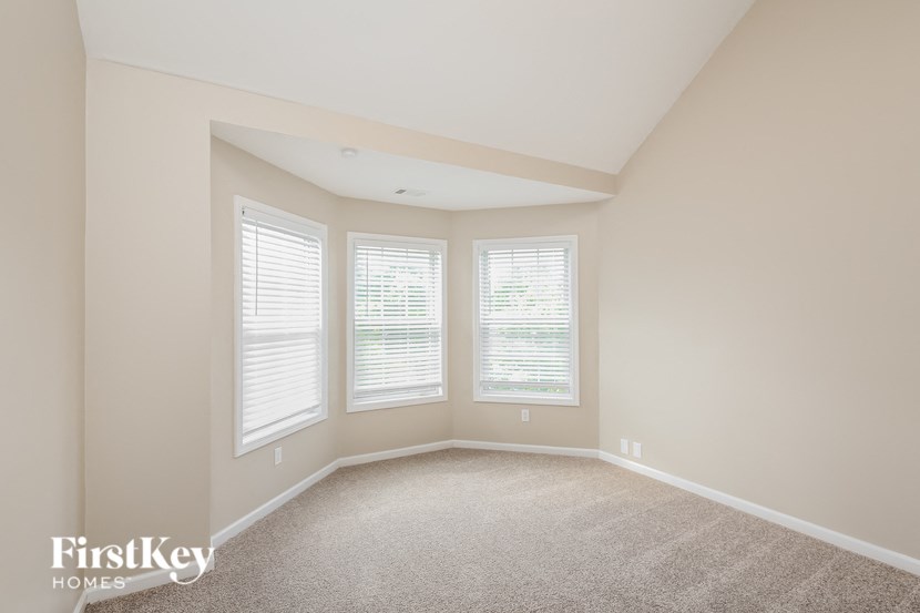 a large empty room with three windows in it