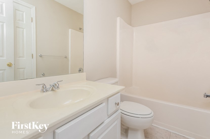 a bathroom with a sink toilet and a mirror