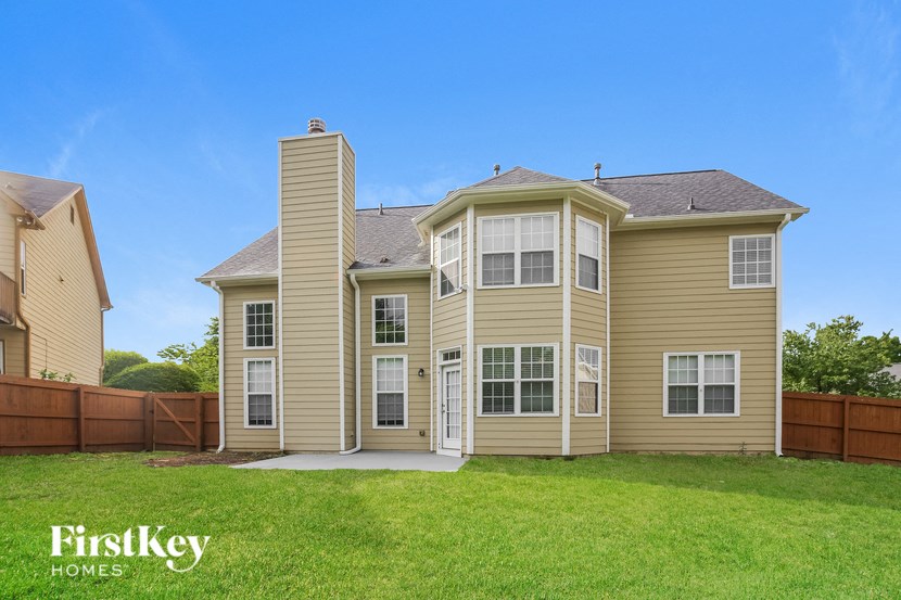 a house with a grassy yard and a wooden fence