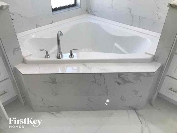 a white bath tub in a bathroom with a sink