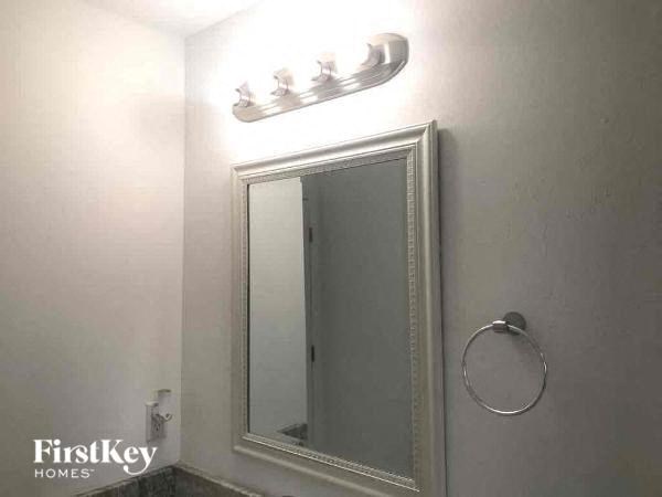 a bathroom with a mirror and a light on the wall