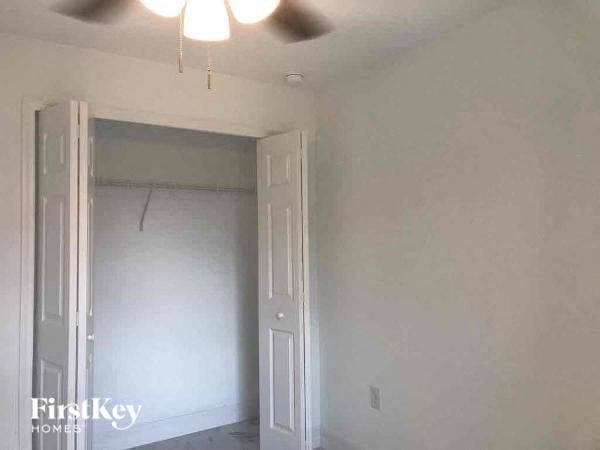 an empty room with a door and a ceiling fan