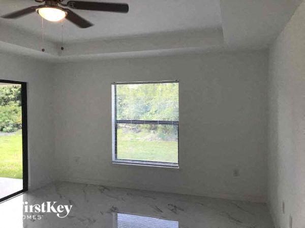 an empty room with a window and a ceiling fan