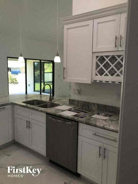 a kitchen with white cabinets and a sink