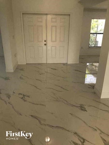 a living room with a marble floor and a white door