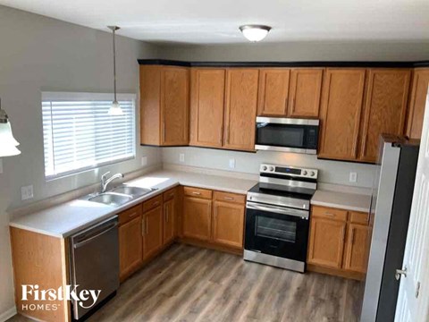 A kitchen with wooden cabinets and a stainless steel dishwasher.