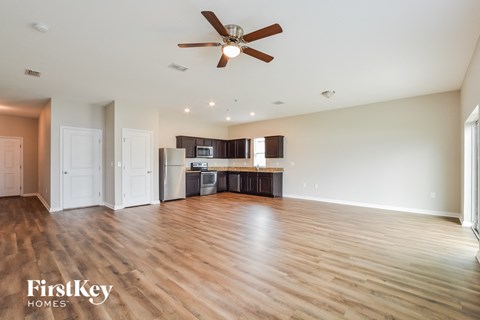 A spacious room with a ceiling fan and wooden flooring.