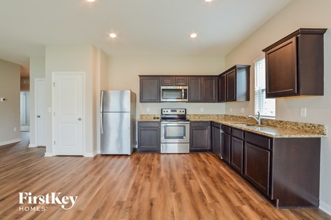 A kitchen with wooden cabinets and a stainless steel refrigerator.