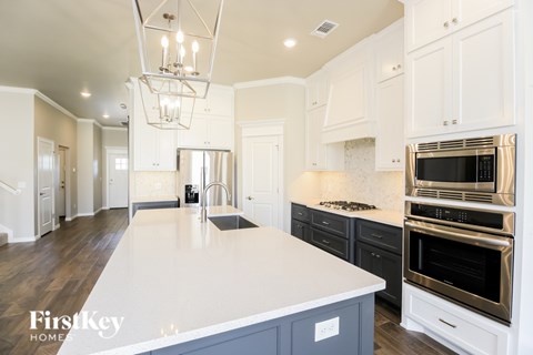 A kitchen with a white counter top and a stainless steel oven.