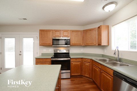 A kitchen with wooden cabinets and a green countertop.