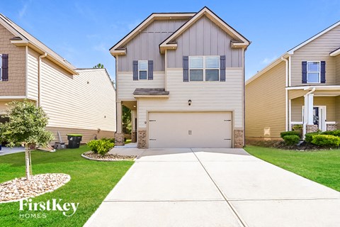 a beige and tan house with a white garage door