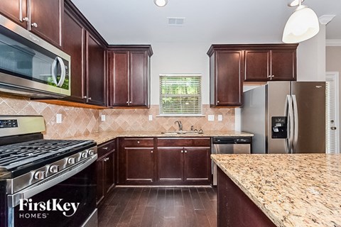 a kitchen with wood cabinets and granite counter tops and stainless steel appliances