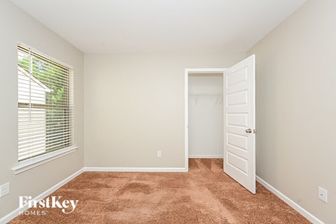 a bedroom with a closet and a window and a door