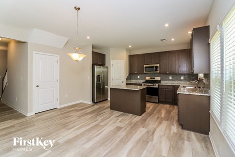 A kitchen with brown cabinets and a white door.