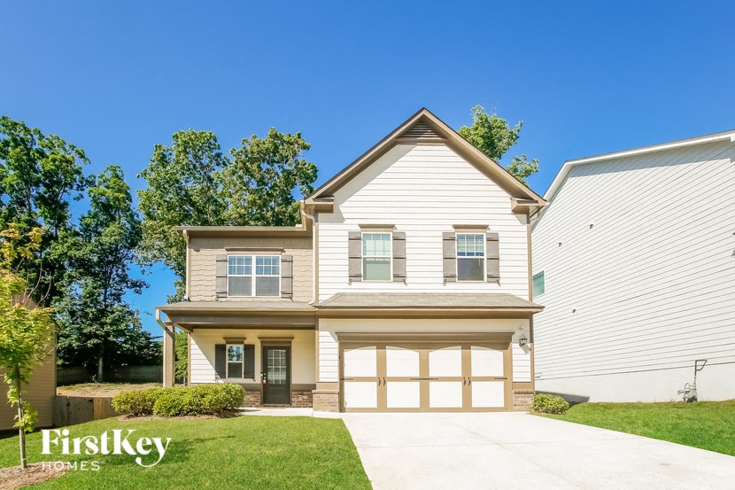 a white house with a garage and a lawn