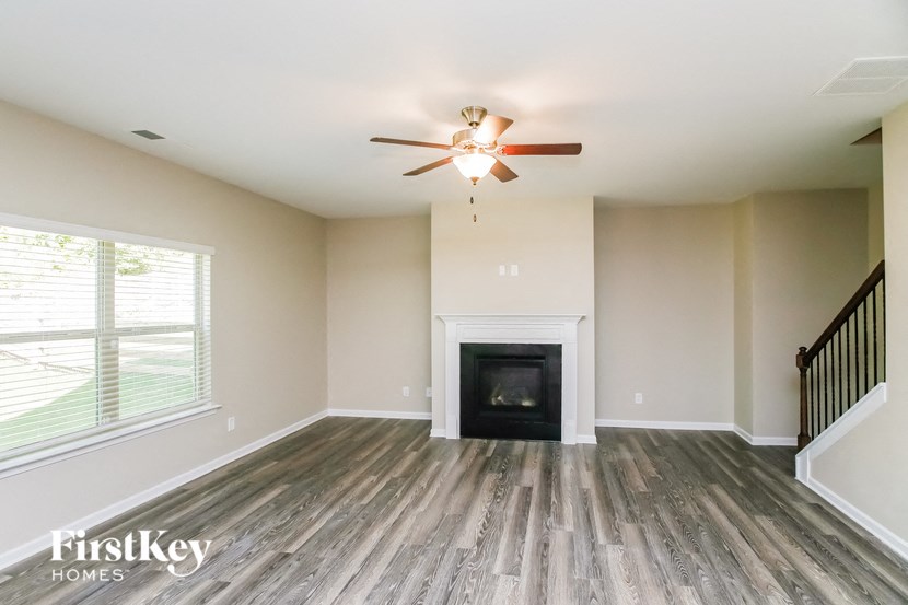 a living room with a fireplace and a ceiling fan