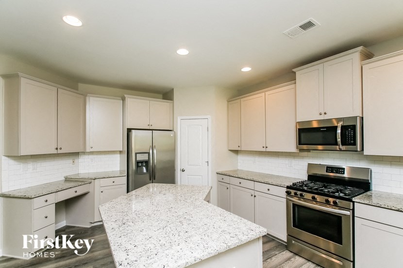 a kitchen with white cabinets and stainless steel appliances