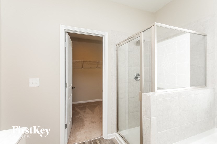 a bathroom with a shower and a door to a closet