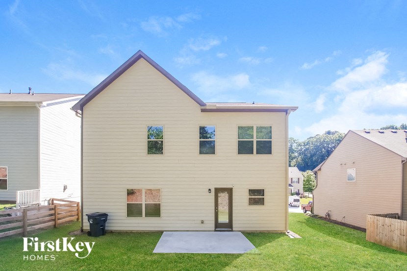 front view of a white house with a driveway and grass