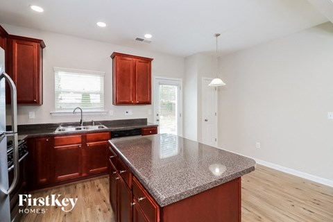 A kitchen with wooden cabinets and a granite countertop.