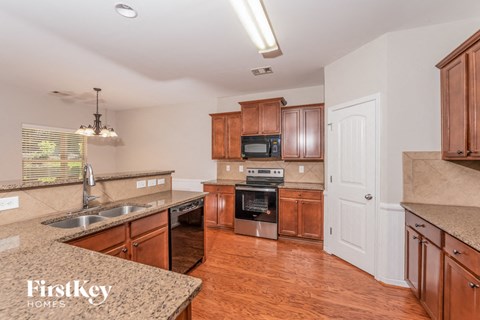 A kitchen with wooden cabinets and a granite countertop.