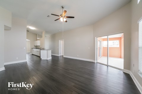 A spacious room with a ceiling fan and wooden flooring.