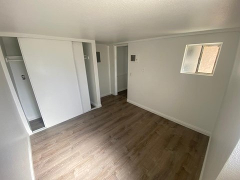A room with wooden flooring and white walls.