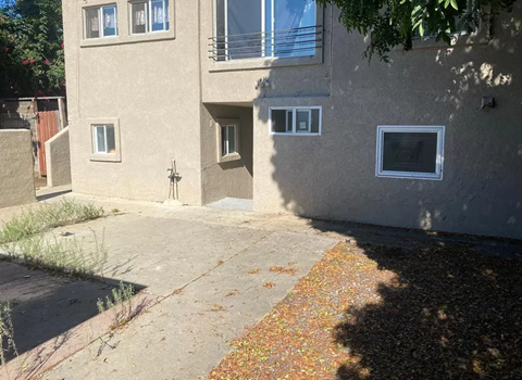 A concrete building with a small window and a door.