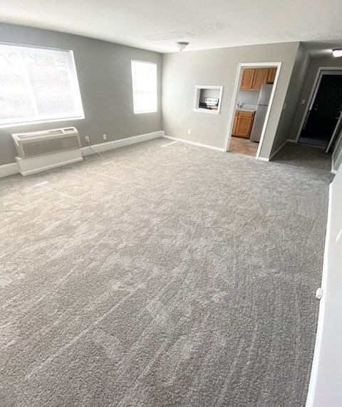 an empty living room with a carpeted floor