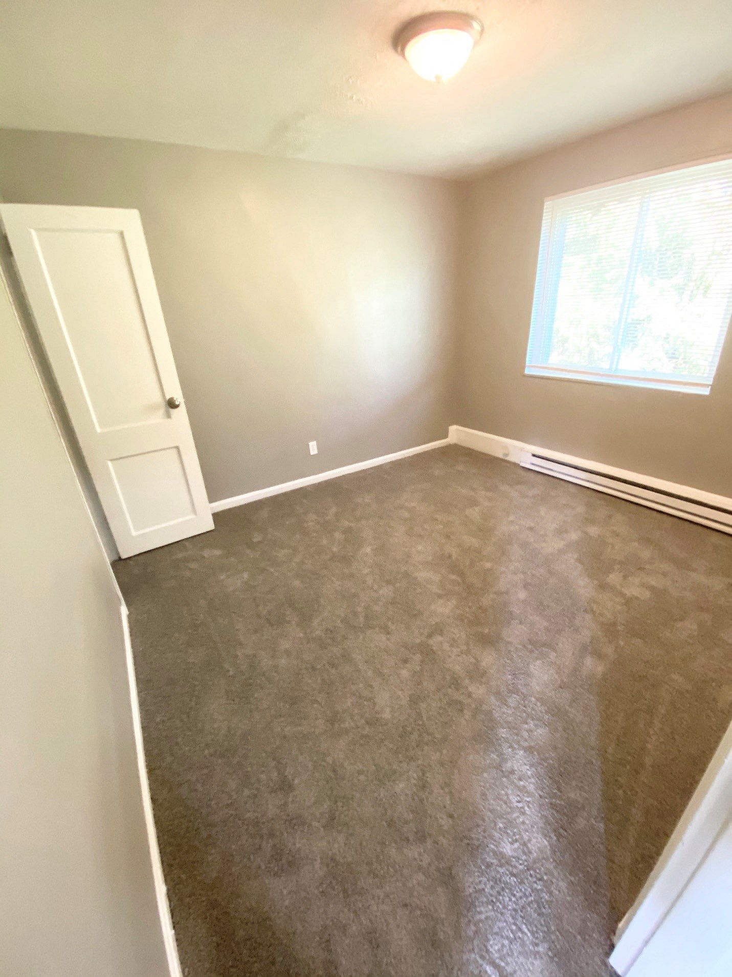 an empty room with a carpeted floor and a door