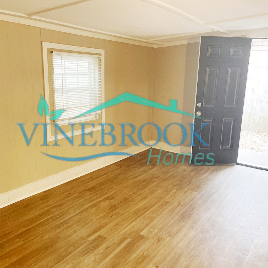 a living room with a hard wood floor and a door