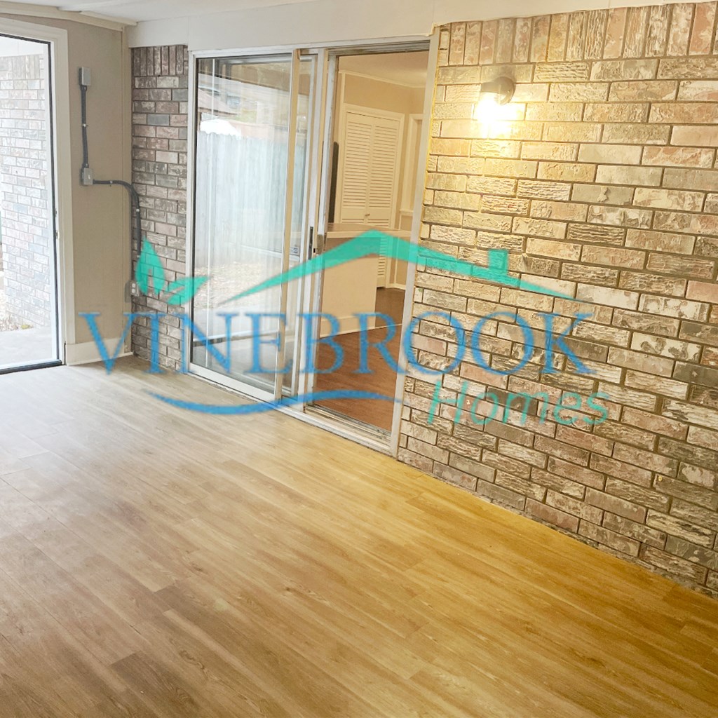 a living room with a brick wall with blue graffiti on it