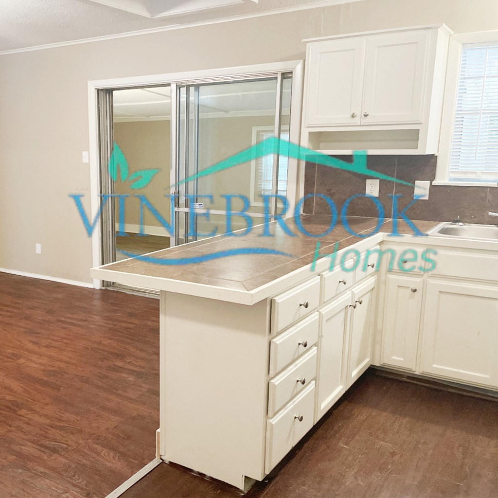 a kitchen with white cabinets and a counter top