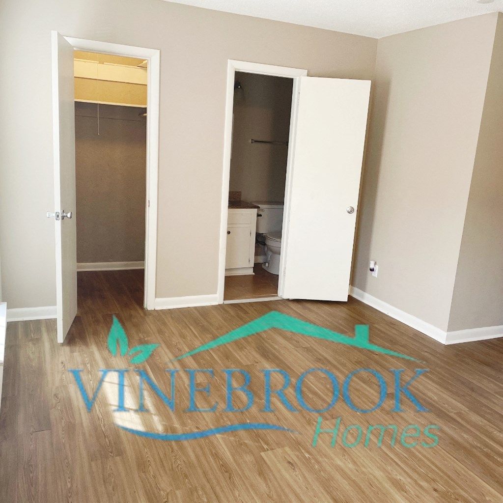 an empty room with a hard wood floor and a closet