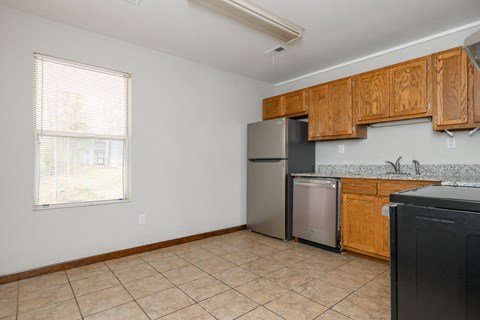 a kitchen with wooden cabinets and a stainless steel refrigerator