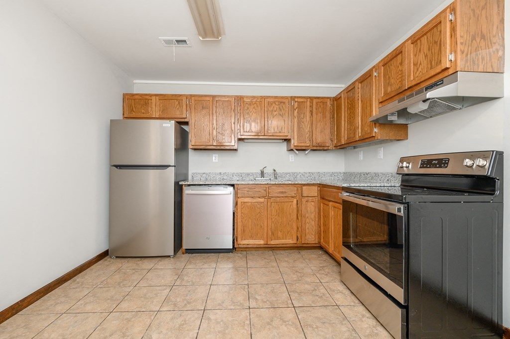 a kitchen with wooden cabinets and stainless steel appliances