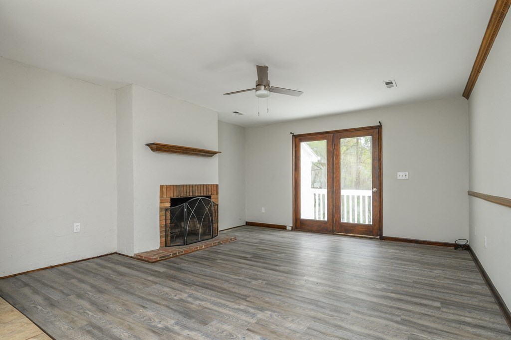 an empty living room with a fireplace and a sliding glass door